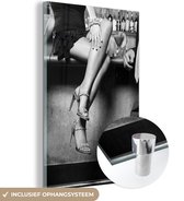 MuchoWow® Glasschilderij 60x90 cm - Schilderij acrylglas - Vrouw met hakken zit op de bar - zwart wit - Foto op glas - Schilderijen