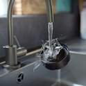 Blender mes wordt afgespoeld onder een kraan in een gootsteen.