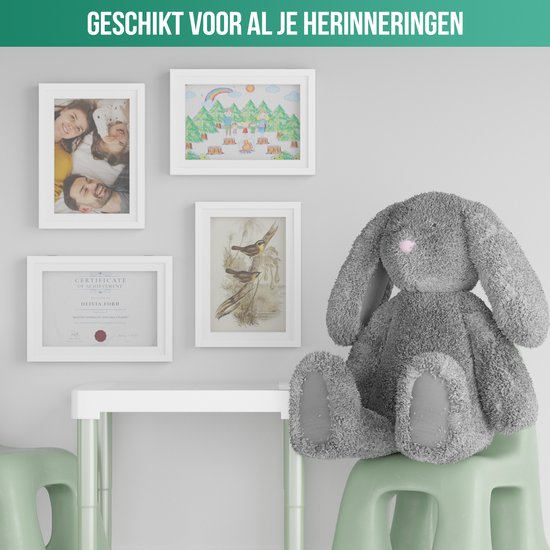 Dessin d'enfant blanc avec arc-en-ciel et arbres, accroché à un mur à côté de cadres photo avec des images et un certificat.