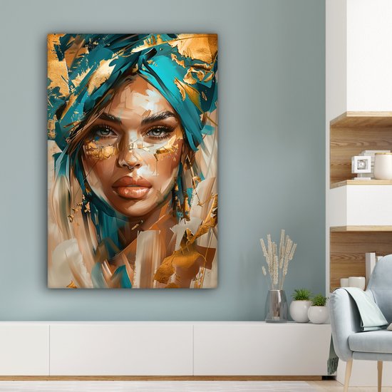 Schilderij van een vrouw met blauwe tulband en gouden details, hangend aan een blauwgrijze muur.