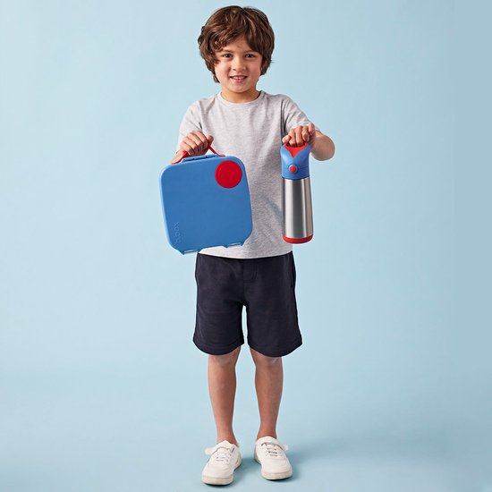 Jongen met blauwe lunchbox en zilveren drinkfles met rode details.