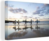 Canvas Schilderij Surfers langs het strand - 120x80 cm - Wanddecoratie