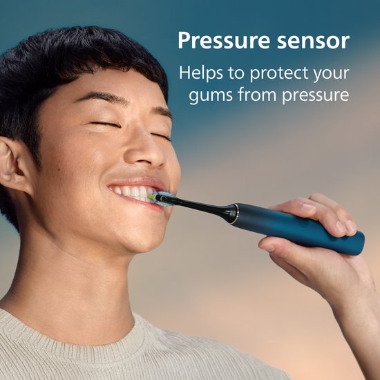 Een man met gesloten ogen poetst zijn tanden met een donkerblauwe Philips Sonicare elektrische tandenborstel.