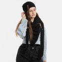 Vrouw in denim jas, zwart shirt, zwarte jeans en zwarte gebreide sjaal en muts, witte achtergrond.