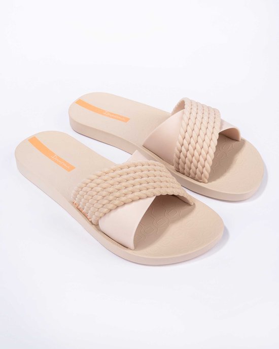 Lichtbruine Ipanema slippers met gevlochten band en oranje logo op de zool.