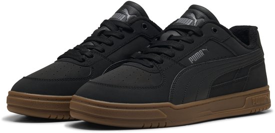 Paar zwarte Puma sneakers met bruine zolen, PUMA logo op zijkant.