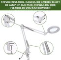 Witte loeplamp met verstelbare arm, tafelklem en veren voor stabiliteit en flexibiliteit.