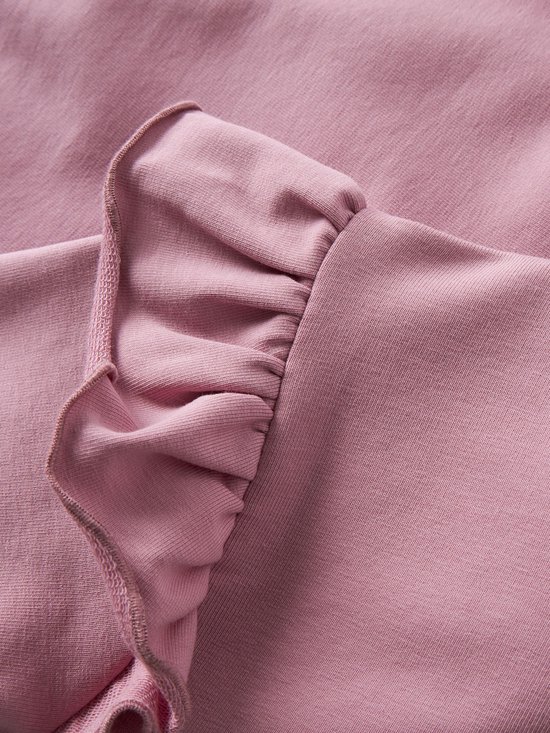 Detail van ruches op een roze sweater.
