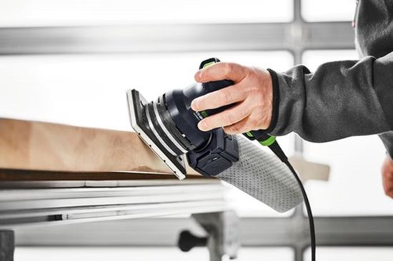 Persoon schuurt een houten plank met de Festool RTS 400 REQ en stofzak.
