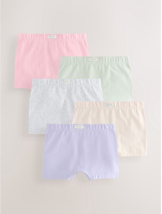 Set van vijf katoenen meisjesboxers in roze, groen, grijs, crème en lila met label met drie hartjes.