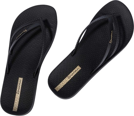 Zwarte Ipanema slippers met gevlochten bandjes en gouden logo op een witte achtergrond.