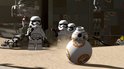 Lego BB-8 met oranje accenten en drie Lego stormtroopers met wapens in de woestijn.