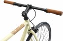 Detail van de crèmekleurige damesfiets: stuur met bruine handvatten en stuurpen.