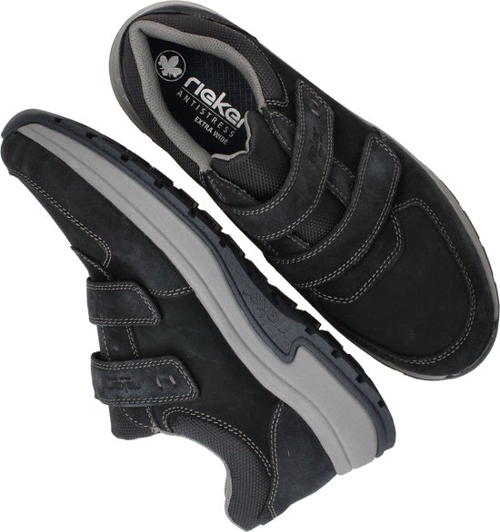 Paar zwarte Rieker sneakers met klittenbandsluiting, een schoen ondersteboven met de zool zichtbaar.