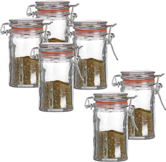 Ensemble de six petits bocaux Weck en verre avec joint orange et fermeture à levier, remplis d'épices.