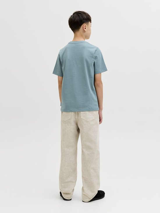 Achterkant jongen in petrolblauw T-shirt met 'JACK & JONES' print en beige broek.