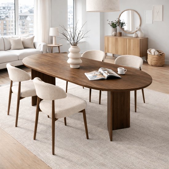Ovale eettafel van donker hout met vier beige stoffen stoelen met houten frame.