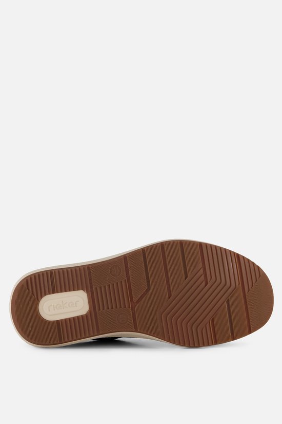 Onderkant van een groene sneaker met bruin profielzool.