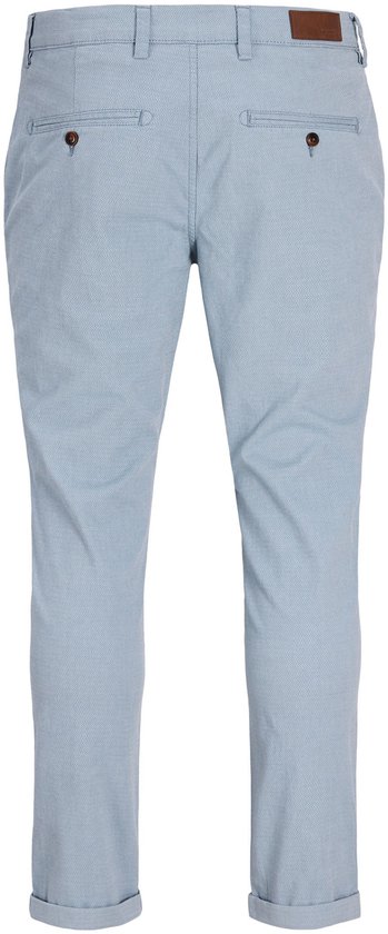 Lichtblauwe pantalon met subtiel ruitpatroon, twee achterzakken met knoopsluiting en omgeslagen broekspijpen.