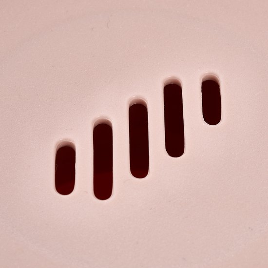 Detail van de roze fruitschaal met vier afwateringssleuven.