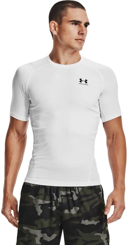 Man met korte mouwen, wit compressie-shirt van Under Armour met zwart logo, en camouflage short.