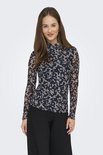 Model in longsleeve met hoge hals, abstracte print in nachtblauw en beige, met zwarte broek.