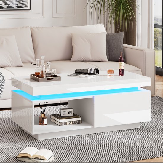 Witte hoogglans salontafel met blauwe LED-verlichting, open vakken en een gesloten gedeelte met een lade, in een woonkamer.