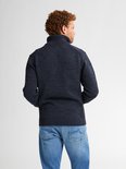 Donkerblauwe gemêleerde gebreide trui met opstaande kraag, van de rug gezien.