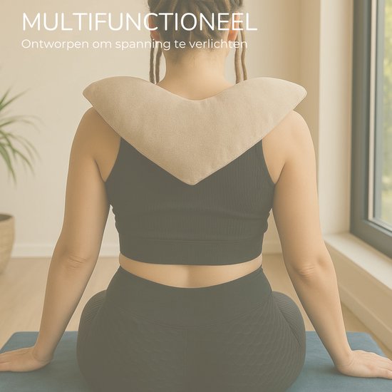 Zijaanzicht van vrouw met dreadlocks die een beige hartvormig verzwaringskussen om haar nek draagt, zittend op een yogamat.