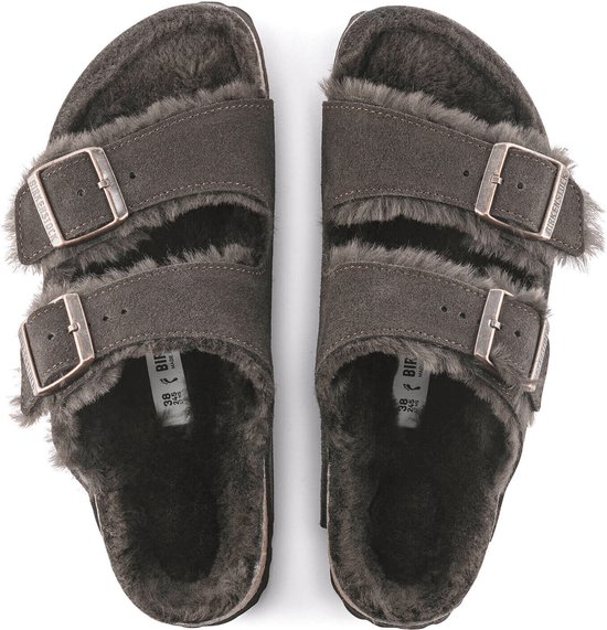 Bovenaanzicht van een paar donkerbruine Birkenstock Arizona pantoffels met dubbele gespen en zachte lammenvacht voering.