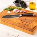 Japans koksmes met damascus print en donkerhouten handvat op houten snijplank met knoflook.
