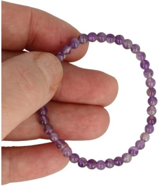 Hand houdt een armband vast van kleine, paarse amethistkralen.