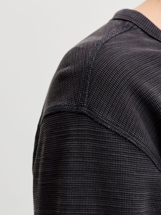 Detailopname van de schouderpartij en textuur van de antracietgrijze henley-top.