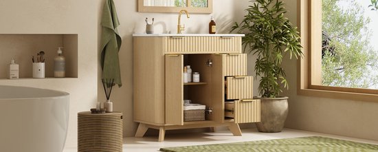 Natuurhouten badmeubel met golvend front, goudkleurige handgrepen, witte wastafel en open kastdeuren.