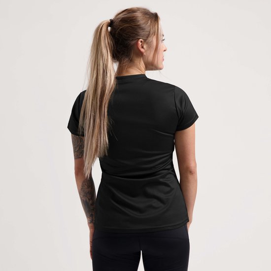 Model van achteren in zwart sportshirt met korte mouwen en V-hals. Zwart trainingsbroek.
