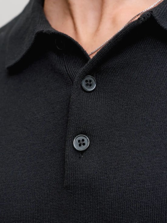 Detail van de knoopsluiting van een zwart Jack & Jones poloshirt.