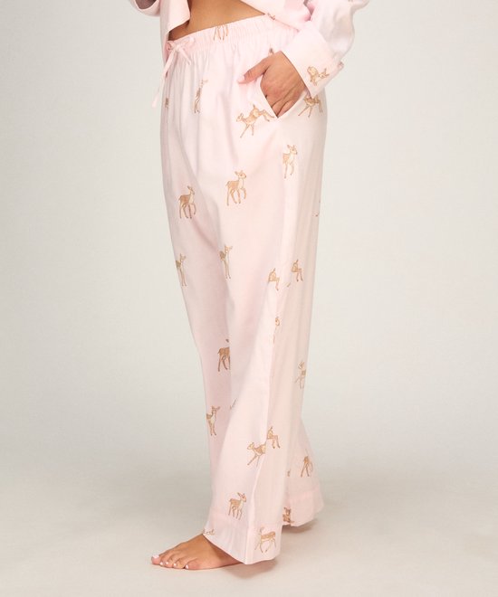 Zijaanzicht van een model met een roze pyjamabroek met hertjesprint, inclusief zijzakken.