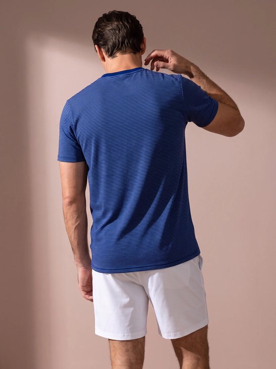 Achteraanzicht van een man in een blauw gestreept sportshirt en witte short.