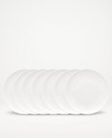 Zeven witte, ronde ontbijtborden van porselein, 18 cm.
