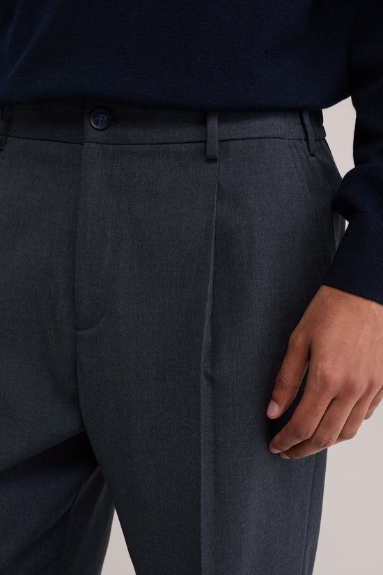 Donkerblauwe pantalon met bandplooi, knoopsluiting en steekzakken.