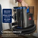Hand pakt de compacte BISSELL SpotClean C5 op, met afmetingen "30 CM BREEDTE, 29,2 CM HOOGTE, 21 CM DIEPTE".