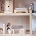 Interieur van een houten poppenhuis met bed, kast, en twee poppetjes. Eén met bril, één met stippen.