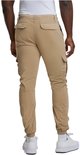Man met beige cargo broek, achterkant zichtbaar, met zakken en elastische enkelbanden.