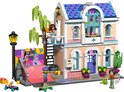 LEGO Friends Liann's Familiehuis met roze huis, blauwe ramen, skateboardbaan en vier poppetjes.