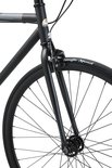 Voorvork en wiel van een zwarte singlespeed fiets met witte bandenletters.