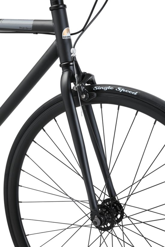 Voorvork en wiel van een zwarte singlespeed fiets met witte bandenletters.