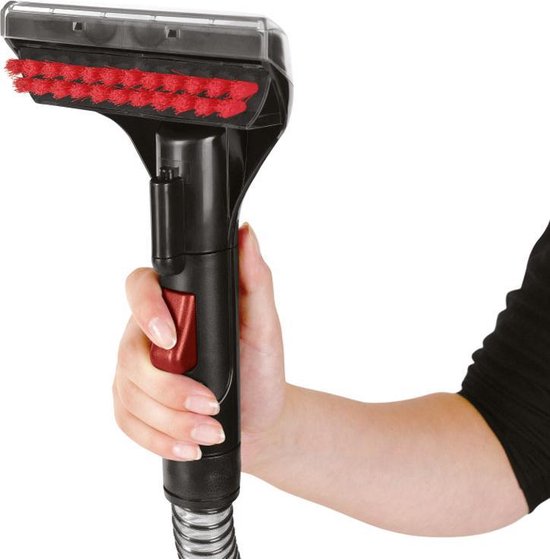 Hand houdt een zwarte en rode schoonmaakborstel met rode borstelharen vast.