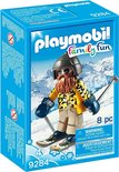 Playmobil skiër met baard, skibril, gele jas met luipaardprint, beige broek en blauwe wanten, op ski's.