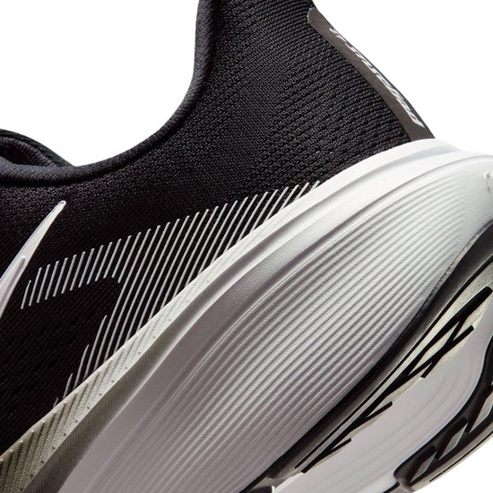 Detail van de zijkant van een zwarte Nike Pegasus 42 hardloopschoen met witte swoosh en gestreepte accenten.