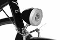Zwarte fietslamp met zilverkleurige rand en heldere lens.